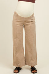 woman wearing beige maternity wide-leg jeans with a stretchy over-the-bump waistband and black sandals.