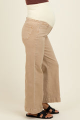 woman wearing a pair of beige maternity wide-leg jeans with a supportive belly panel and black sandals, showing a baby bump