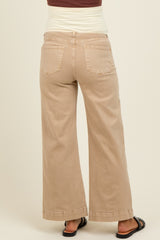 woman wearing beige maternity wide-leg jeans, seen from the back, with a comfortable waistband and casual sandals
