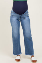 woman wearing blue maternity jeans with a frayed hem and a dark blue maternity band at the waist