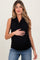 woman wearing a black sleeveless maternity top and holding her baby bump