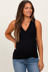 woman wearing a black ribbed maternity tank top with a wrap design and a baby bump visible
