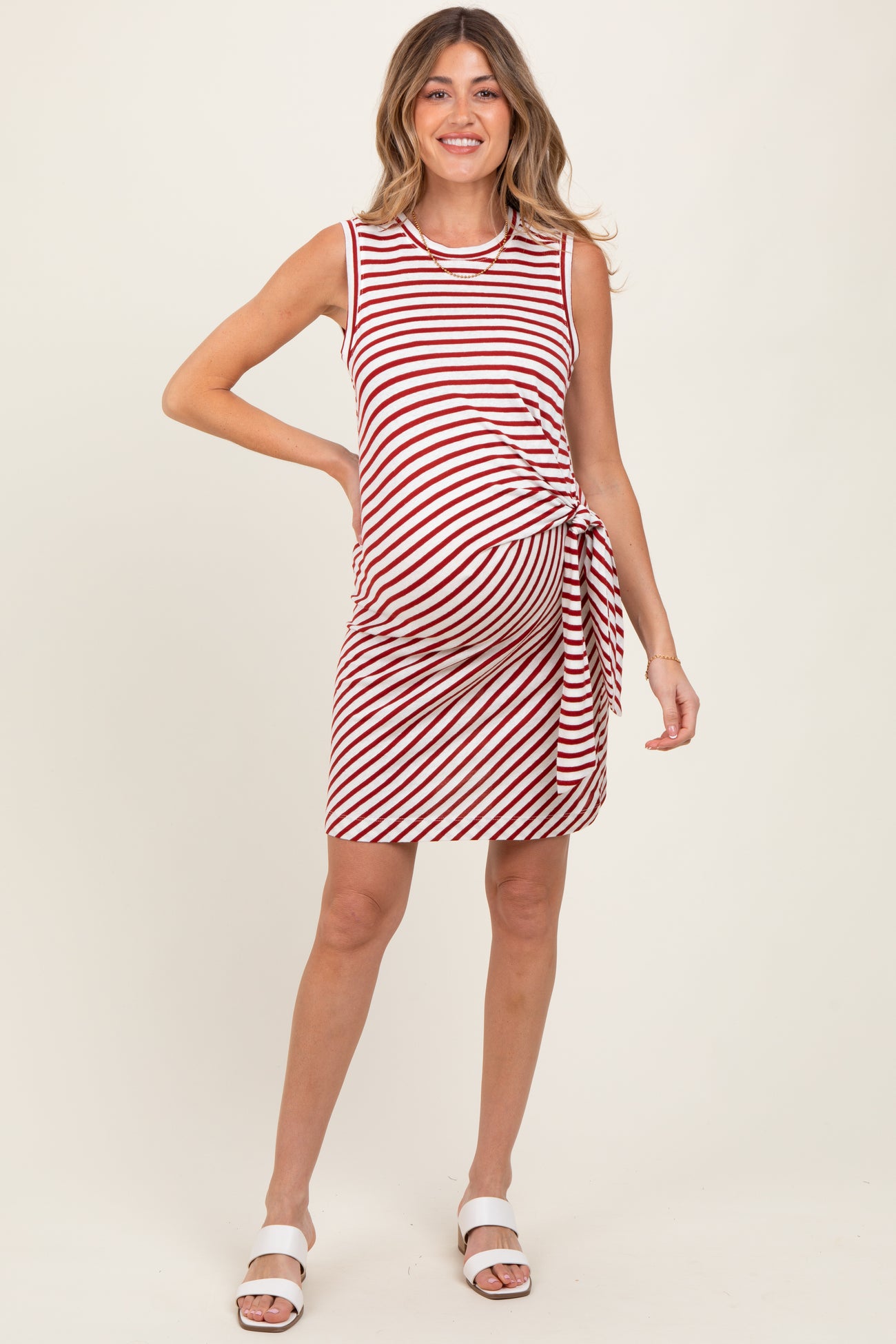 woman wearing a red and white striped maternity dress with a side tie and a visible baby bump