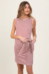 woman wearing a red and white striped sleeveless maternity dress and tying the front in a knot
