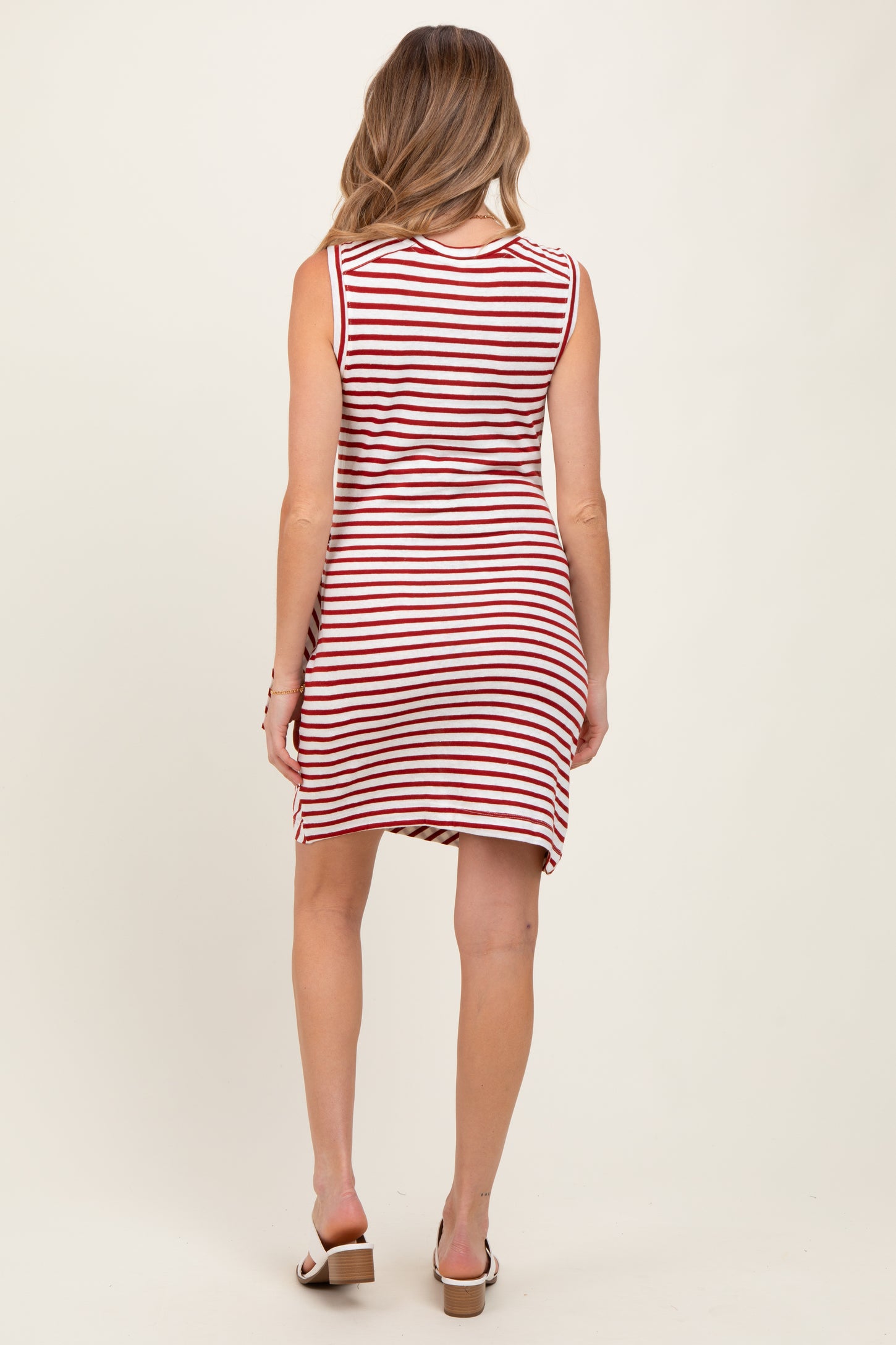 woman wearing a red and white striped maternity dress, shown from the back, with a casual, fitted style