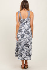 woman wearing a floral print midi dress with striped tie straps and a smocked back