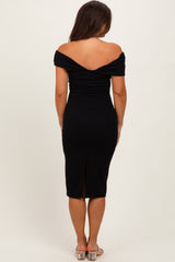 woman wearing a black off-shoulder maternity dress with a fitted silhouette and a back slit
