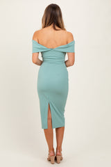 woman wearing a mint green off-shoulder fitted dress with a back slit