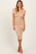 woman wearing a nude off-the-shoulder fitted midi dress with a sweetheart neckline and ruching details