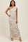 woman wearing a one-shoulder pastel printed maxi dress with ruching details and posing confidently
