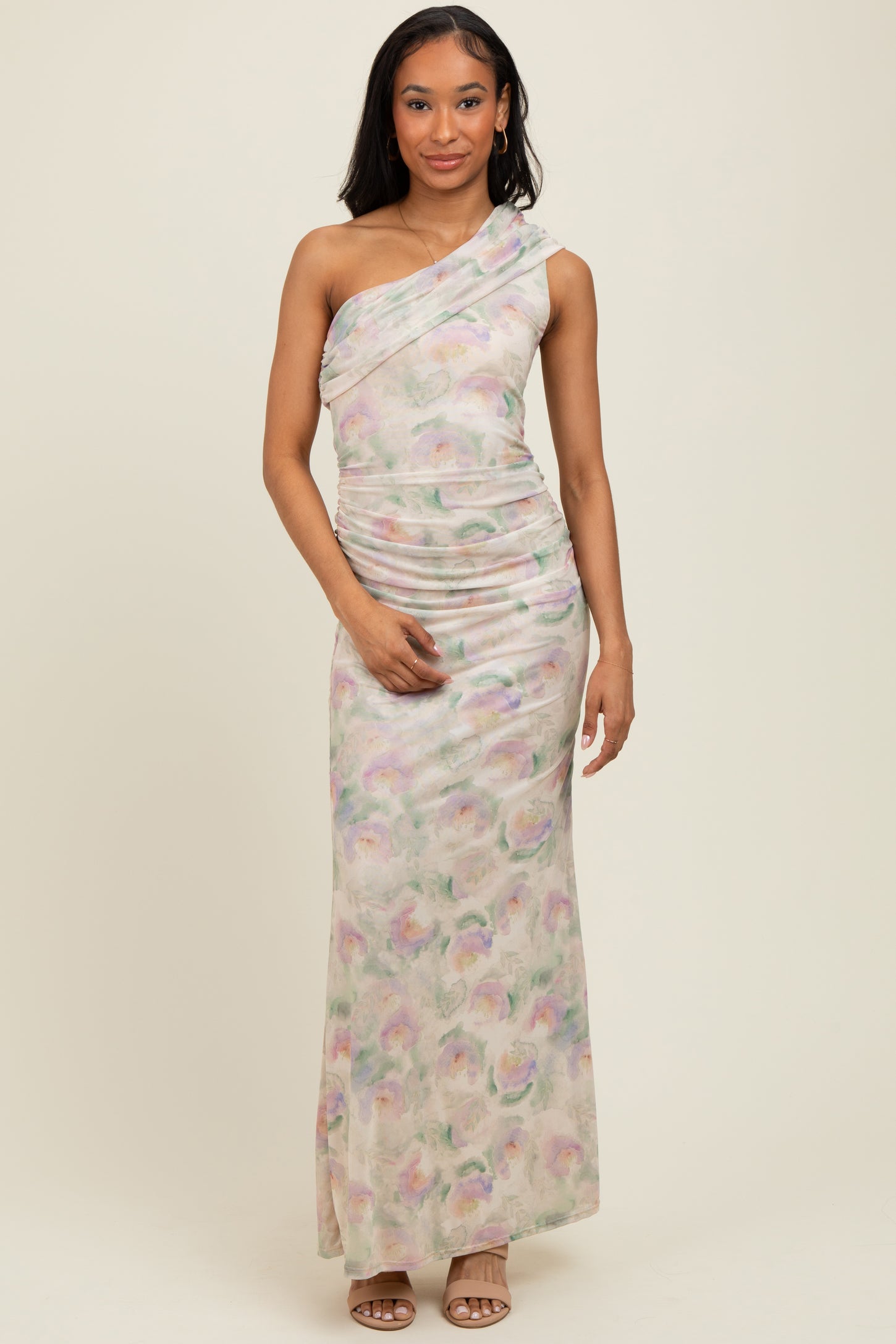 woman wearing a floral print one-shoulder maxi dress with ruching details