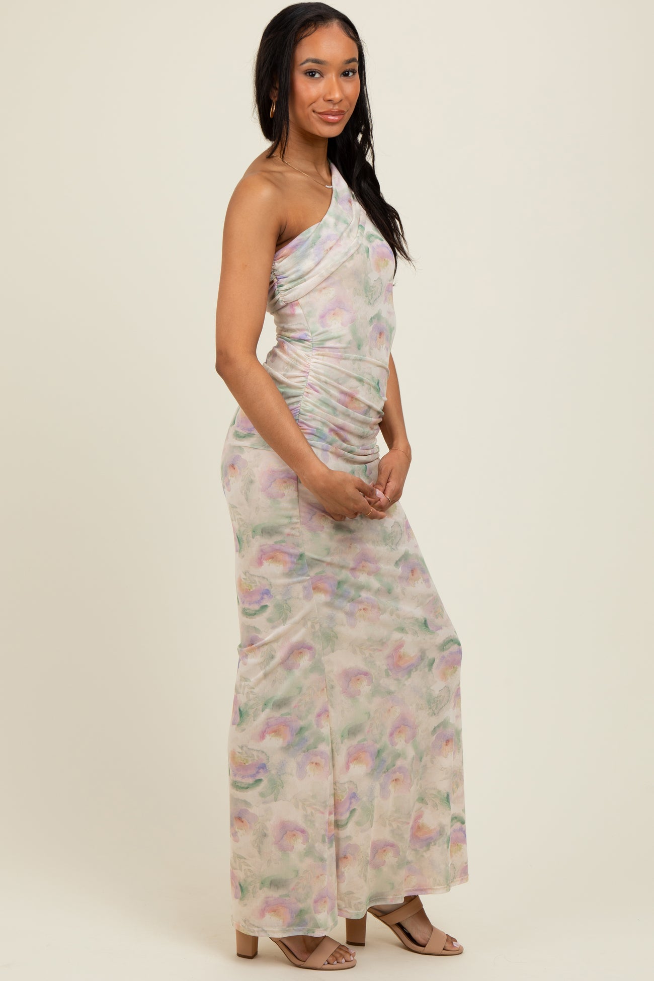 woman wearing a pastel one-shoulder dress with ruched detailing and a flowing silhouette