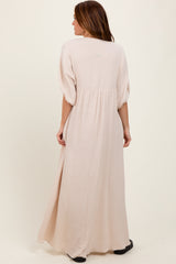woman wearing a long beige maxi dress with puff sleeves and a gathered back detail