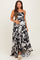 woman wearing a black and white floral print maternity maxi dress, holding her baby bump