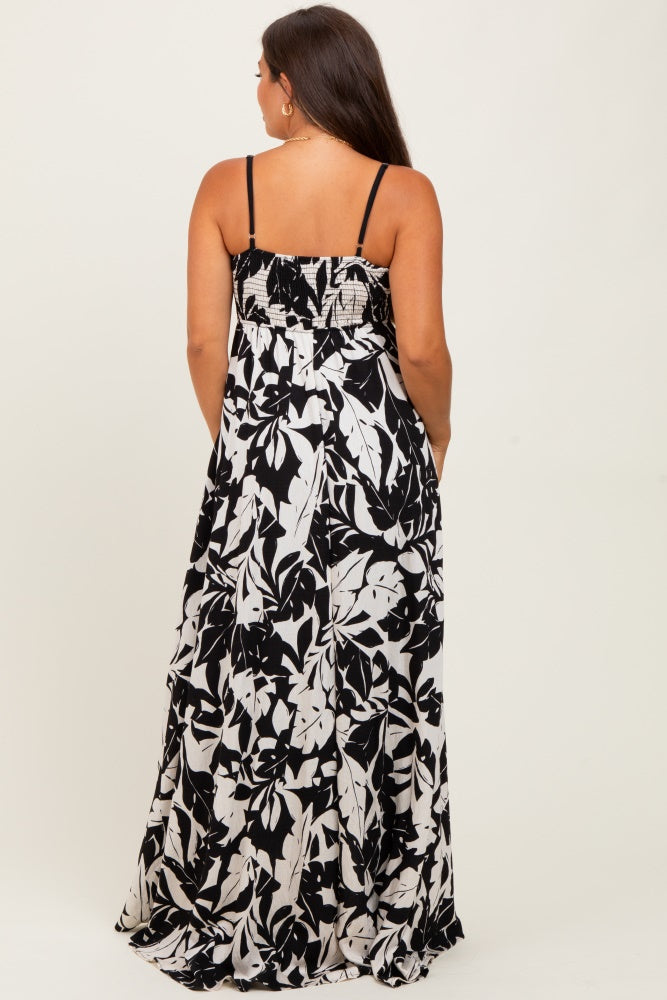 woman wearing a black and white floral print maternity maxi dress, viewed from the back