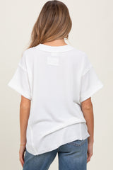woman wearing a white short sleeve maternity top with a relaxed fit and a textured fabric, showing the back view