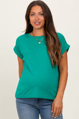 woman wearing a vibrant green short sleeve maternity top and showing her baby bump with casual jeans