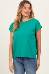 woman wearing a green short sleeve top paired with blue jeans