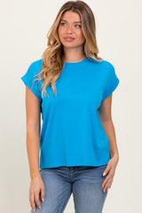 woman wearing a bright blue short sleeve t-shirt with rolled cuffs and relaxed fit, paired with blue jeans