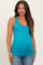 woman wearing a teal maternity tank top and showing her baby bump, paired with blue jeans