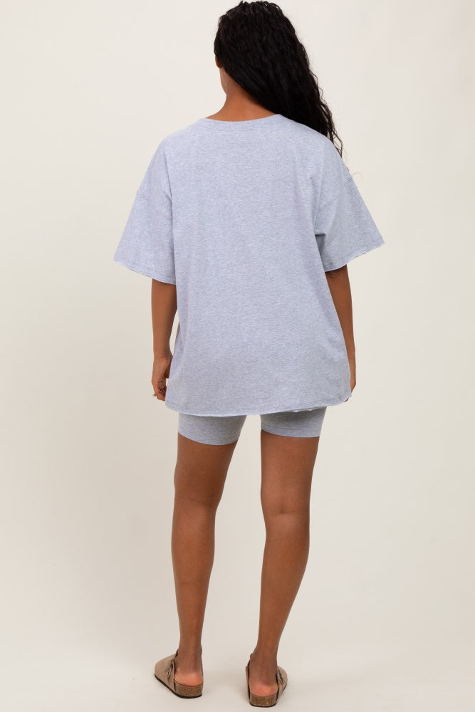 woman wearing a light gray oversized t-shirt and matching shorts, viewed from the back