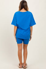 woman wearing a bright blue oversized t-shirt and matching bike shorts, viewed from the back