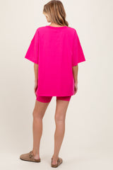 woman wearing a hot pink oversized maternity t-shirt with matching shorts, showing a relaxed fit suitable for maternity wear