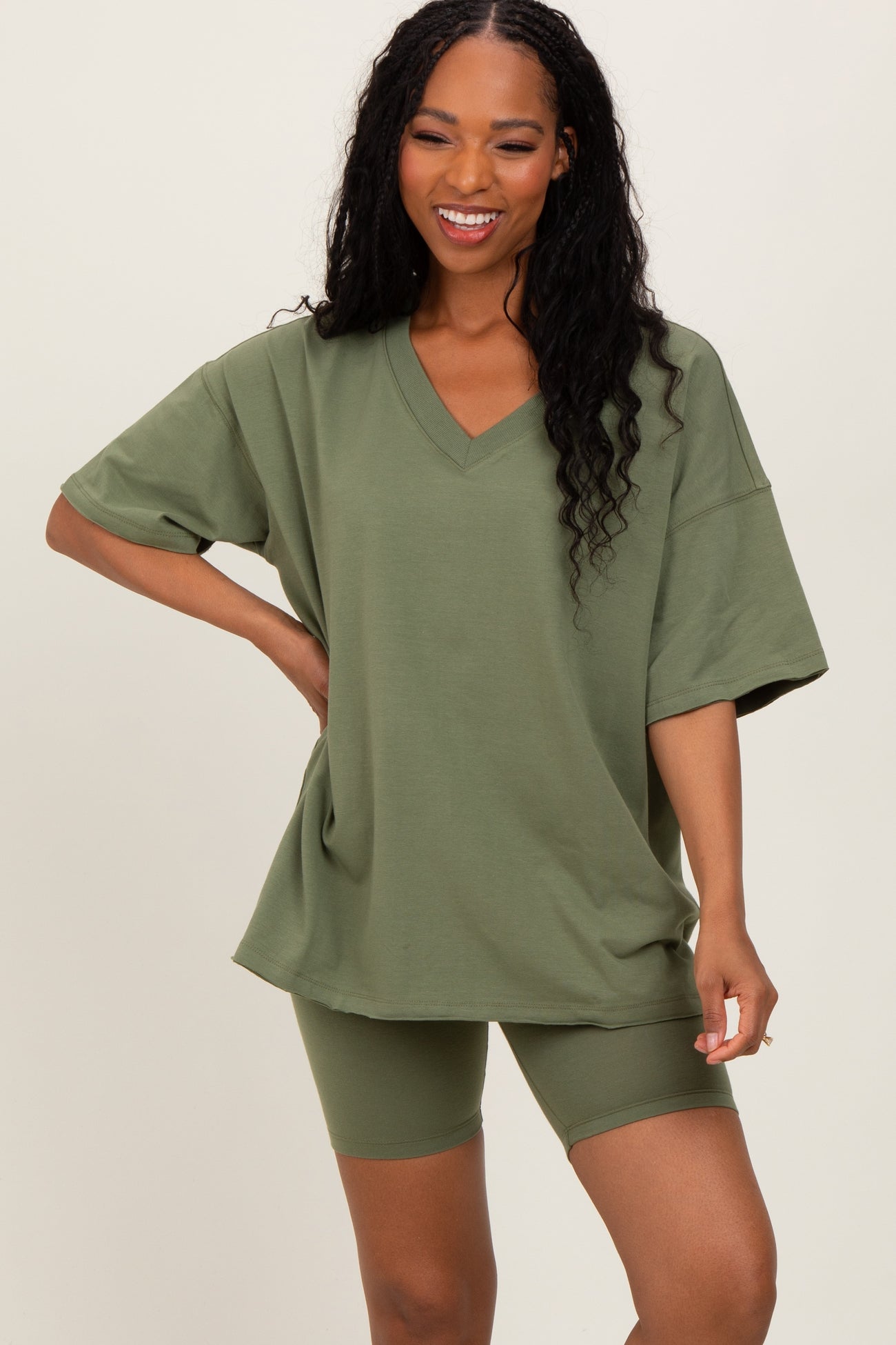 woman wearing an olive green oversized v-neck t-shirt with matching bike shorts
