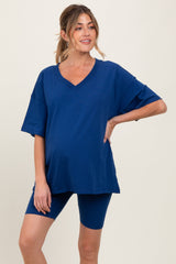 woman wearing a navy blue maternity oversized v-neck tee and matching bike shorts, showing her baby bump