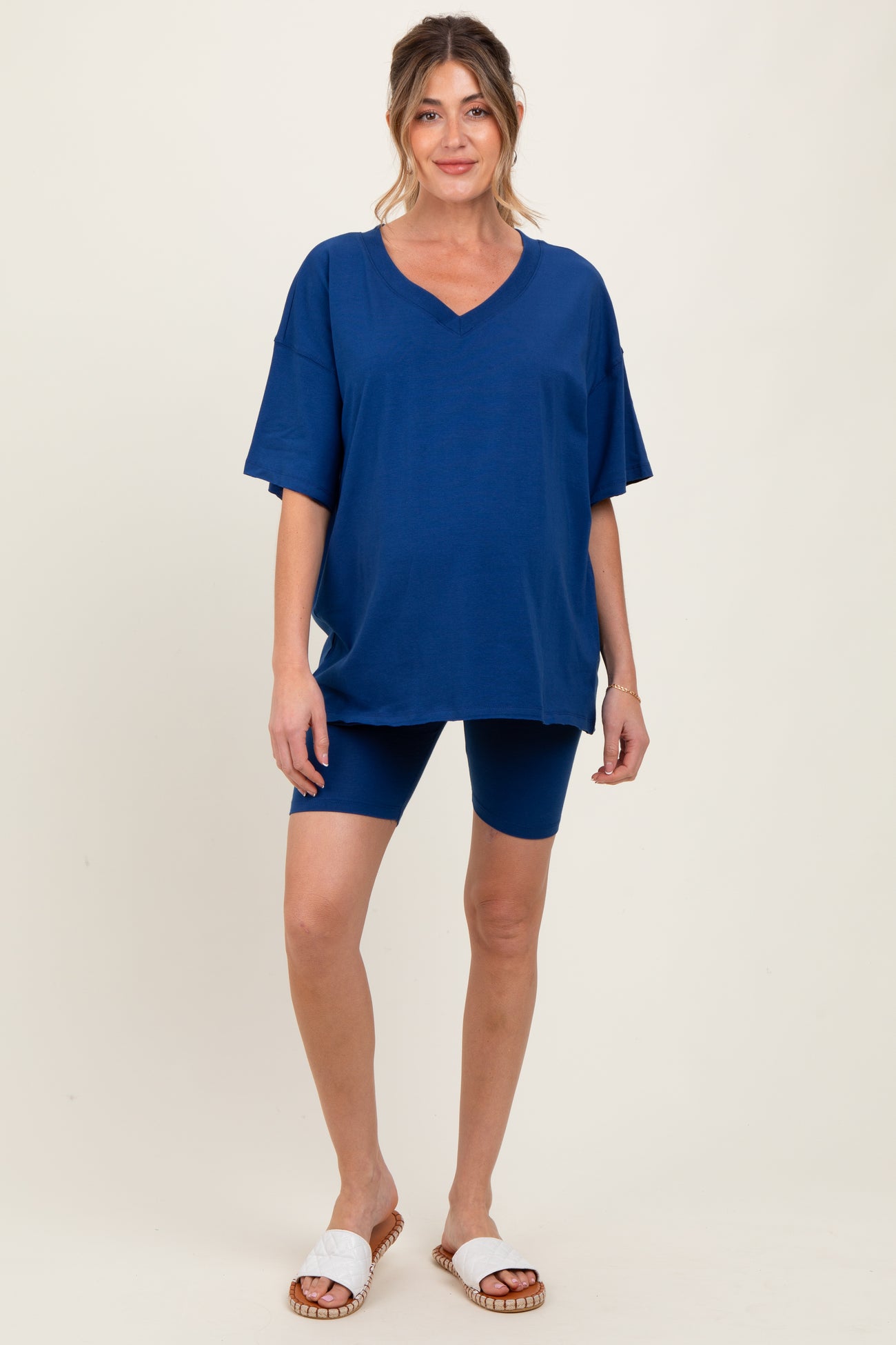 woman wearing a navy blue maternity oversized v-neck t-shirt and matching bike shorts with casual sandals