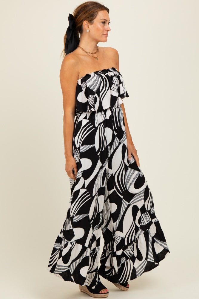 woman wearing a black and white patterned strapless maxi dress with ruffled layers and a bow in her hair