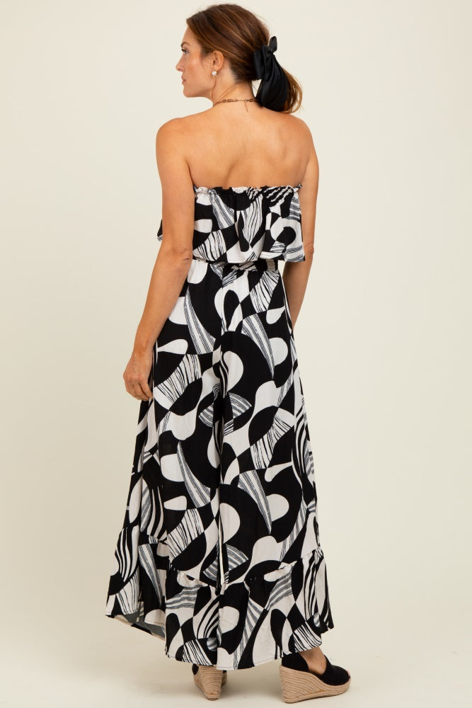 woman wearing a black and white patterned maxi dress with a ruffled top and a flowy skirt