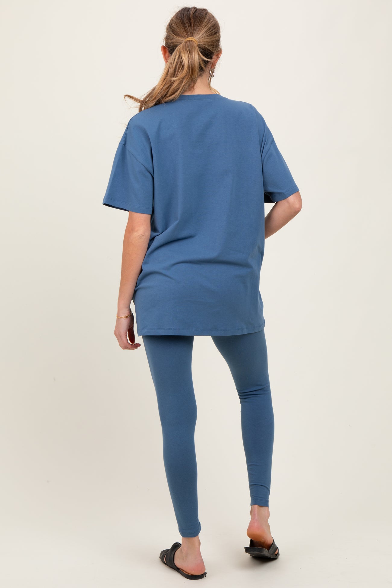 woman wearing a blue oversized t-shirt and matching leggings, maternity wear, showing a casual outfit