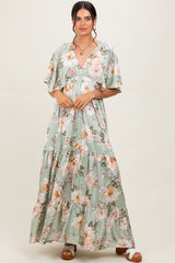 woman wearing a green floral maxi dress with short sleeves and a tiered skirt