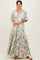 woman wearing a green floral maxi dress with short sleeves and a tiered skirt