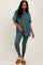 woman wearing a teal oversized t-shirt and matching leggings, styled with brown fuzzy slippers