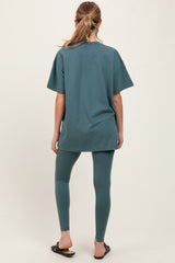 woman wearing a teal oversized maternity t-shirt and matching leggings, with hair in a ponytail, seen from the back