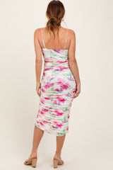 woman wearing a fitted white floral midi dress with adjustable spaghetti straps and a ruched back design