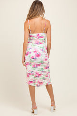 woman wearing a floral ruched maternity dress with adjustable straps, showing the back view