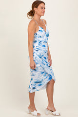 woman wearing a blue and white patterned midi dress with adjustable straps and a ruched side detail
