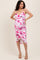 woman wearing a pink and white floral maternity dress with ruching, showing off her baby bump