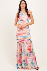 woman wearing a colorful one-shoulder floral maxi dress with ruching and a flowing skirt