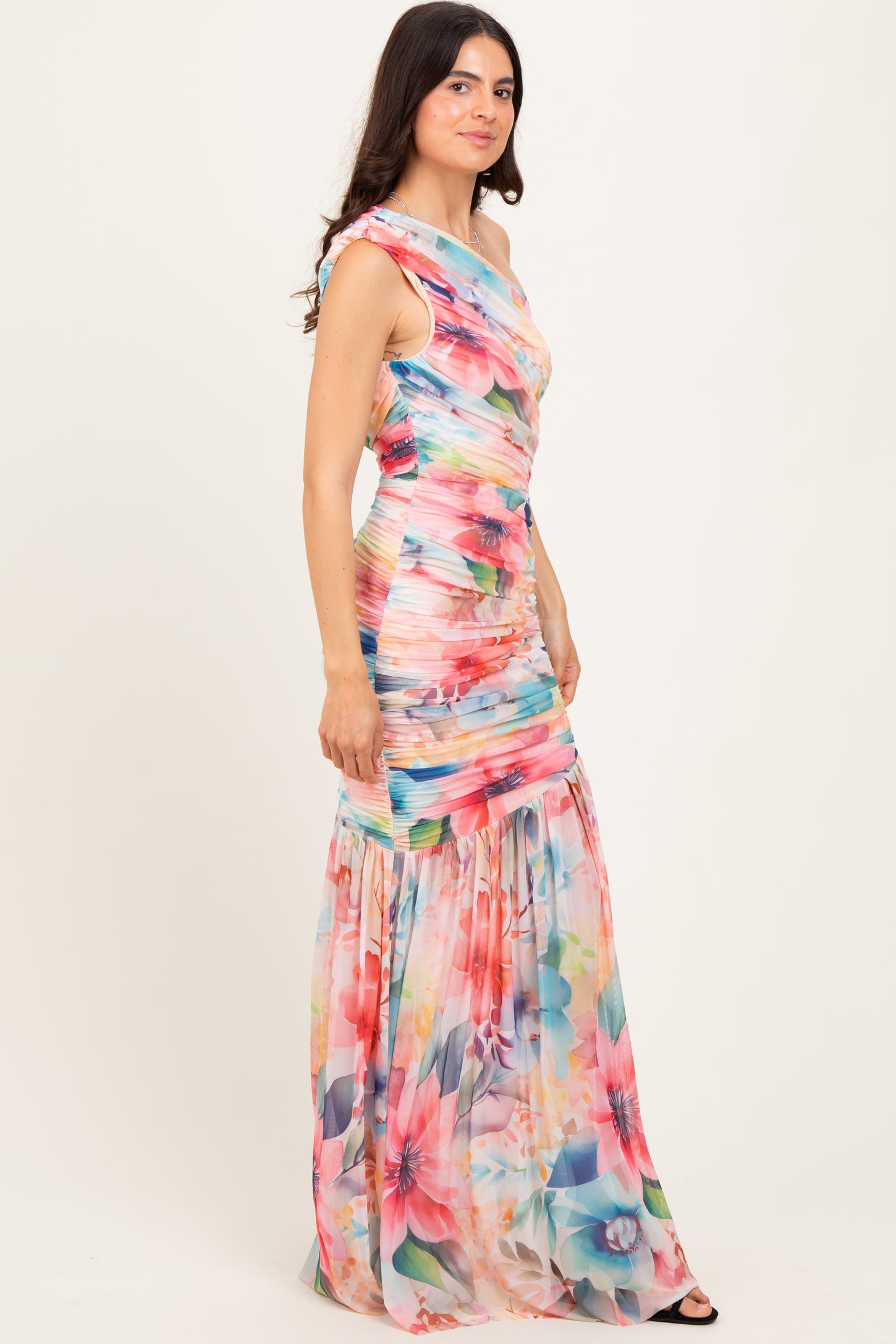 woman wearing a colorful floral maxi dress with a fitted bodice and flowing skirt