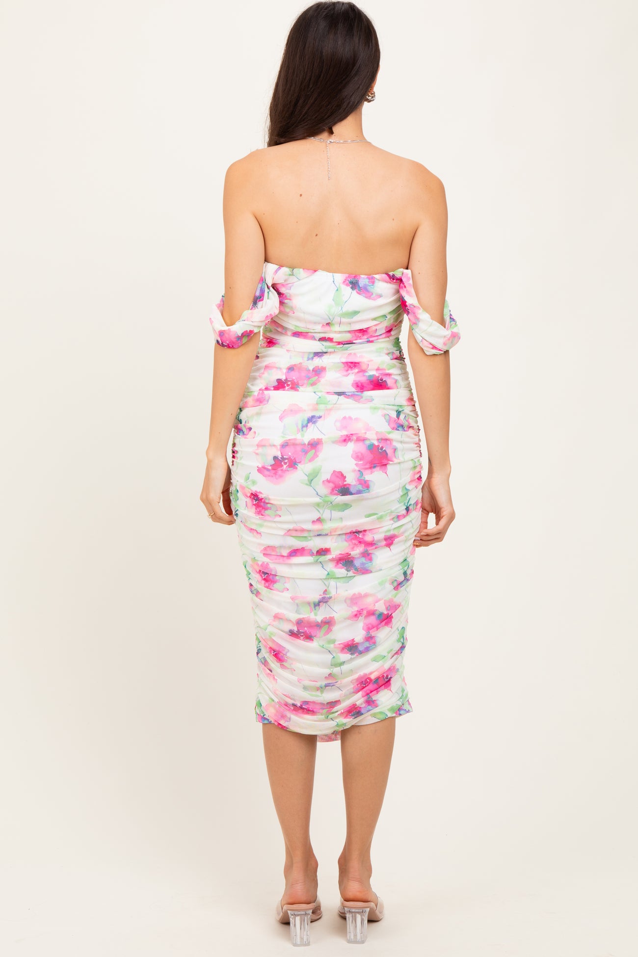 woman wearing a floral print off-shoulder bodycon dress with ruched detailing and short sleeves