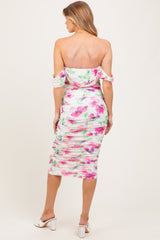 woman wearing a floral off-the-shoulder ruched maternity dress showcasing a fitted silhouette from the back