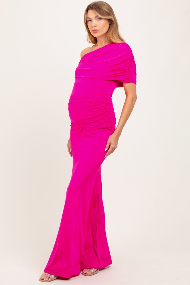 woman wearing a hot pink one-shoulder maternity gown with ruching and a visible baby bump