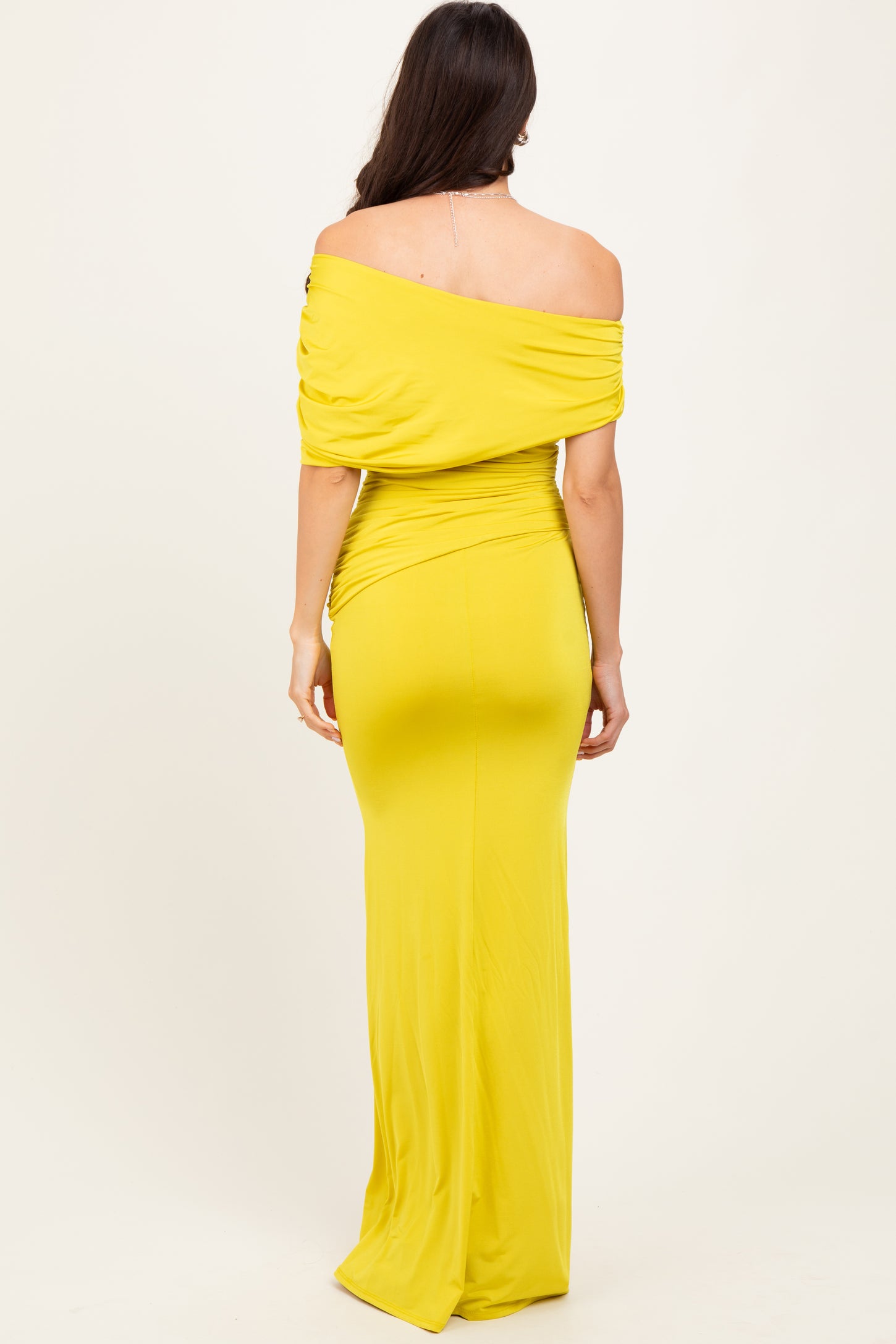 woman wearing a yellow off-the-shoulder fitted maxi dress from the back