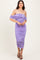 woman wearing a lilac off-shoulder fitted dress with ruched details and a mid-length hem