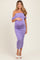 woman wearing a lavender off-shoulder maternity dress with ruching and holding her baby bump