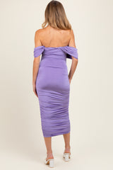 woman wearing a lilac off-the-shoulder maternity dress with ruching, showing a baby bump from the back